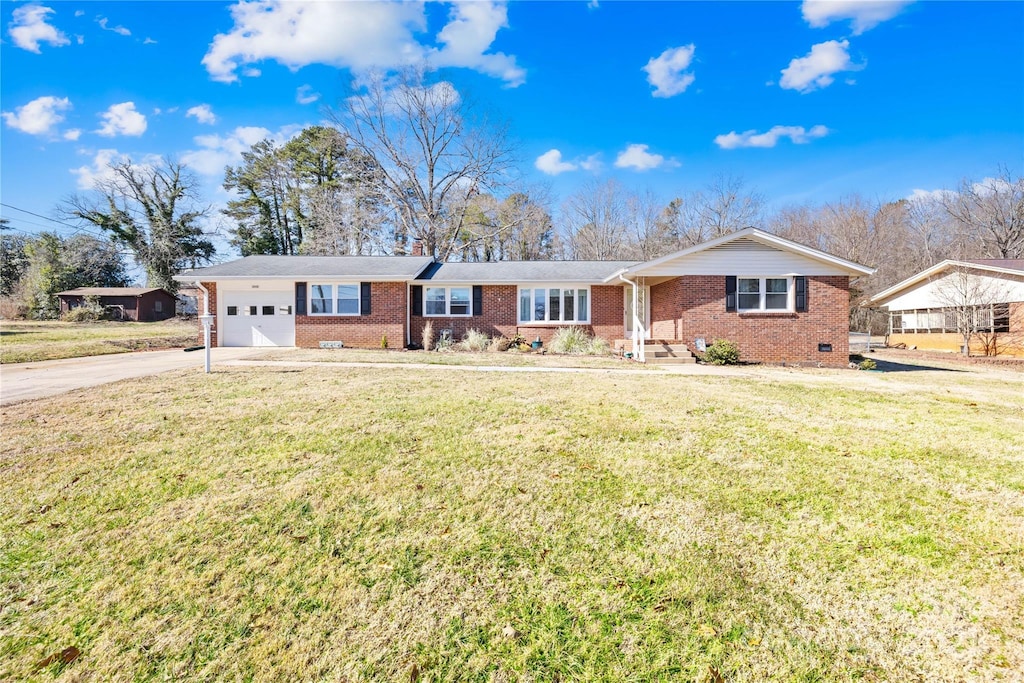 ranch-style home featuring a garage and a front lawn