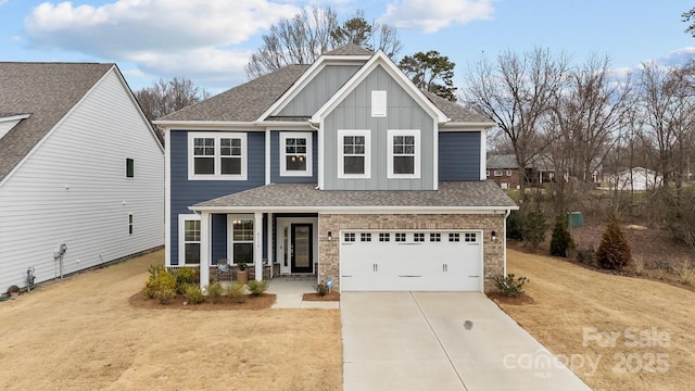 view of front of house featuring a garage, a front yard, and covered porch