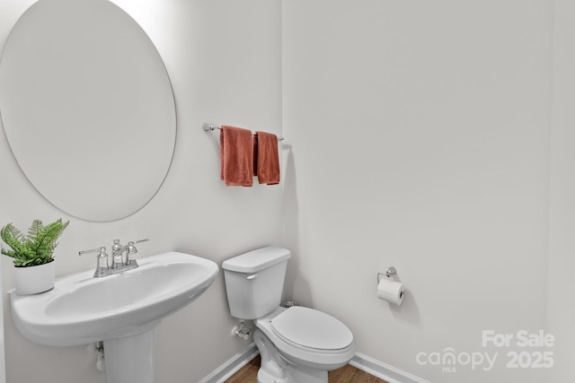 bathroom with sink, toilet, and hardwood / wood-style floors