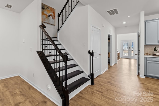 staircase featuring hardwood / wood-style flooring and french doors