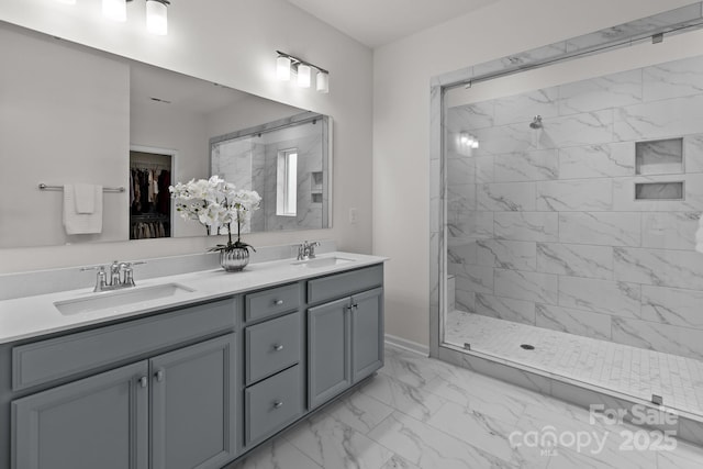 bathroom featuring a tile shower and vanity