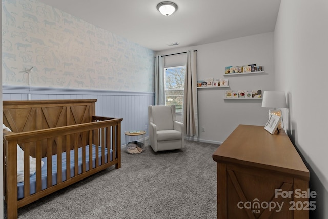 bedroom with carpet and a crib