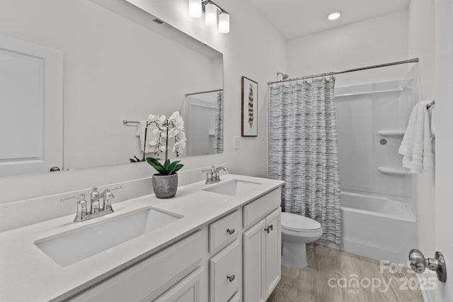 full bathroom with vanity, hardwood / wood-style floors, shower / bathtub combination with curtain, and toilet