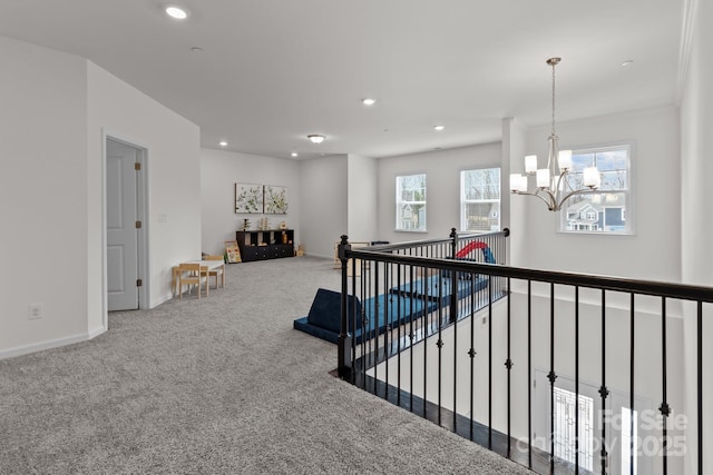 hall featuring carpet flooring and a notable chandelier