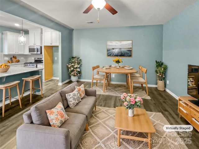 living room featuring dark hardwood / wood-style floors and ceiling fan