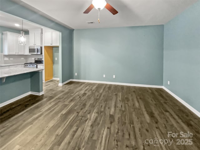 kitchen featuring pendant lighting, ceiling fan, white cabinetry, stainless steel appliances, and dark hardwood / wood-style flooring