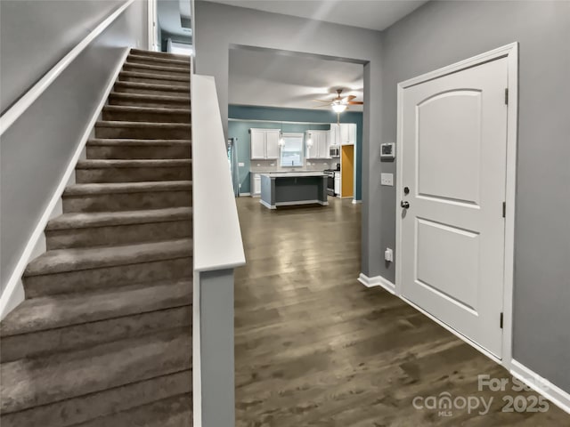 stairway with hardwood / wood-style flooring and ceiling fan