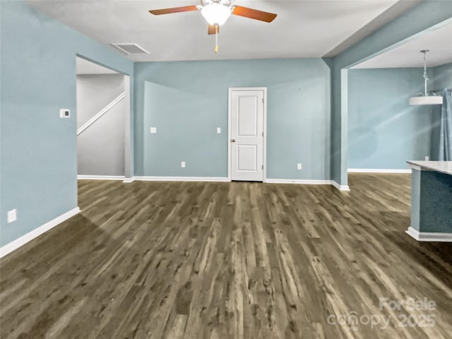 unfurnished living room with dark hardwood / wood-style flooring and ceiling fan