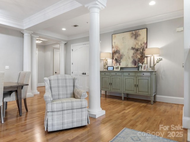 sitting room with ornate columns, ornamental molding, and light hardwood / wood-style flooring