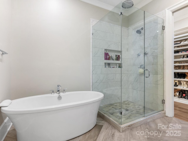 bathroom with ornamental molding and separate shower and tub