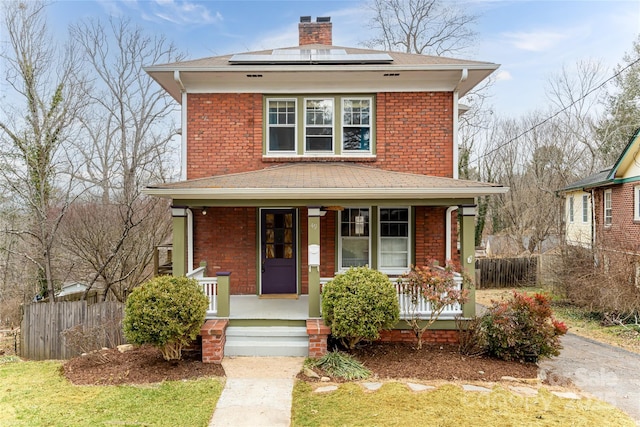 front facade with solar panels and a porch