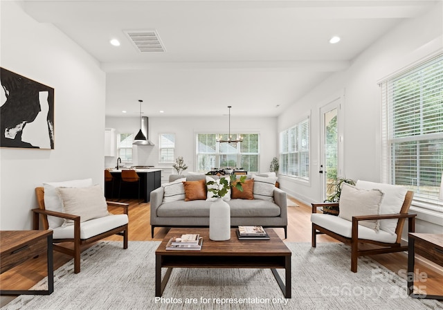 living room featuring light wood finished floors, recessed lighting, visible vents, and a notable chandelier