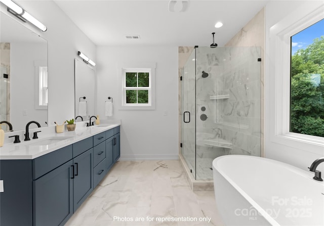 full bathroom with marble finish floor, visible vents, a wealth of natural light, and a sink