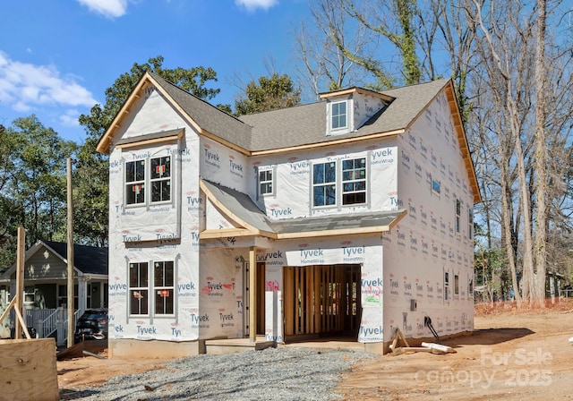 property in mid-construction featuring a garage and roof with shingles