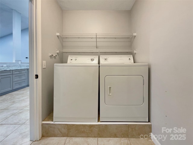 washroom featuring washing machine and dryer and light tile patterned floors