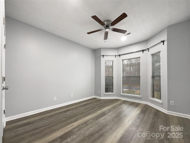 spare room with dark wood-type flooring and ceiling fan