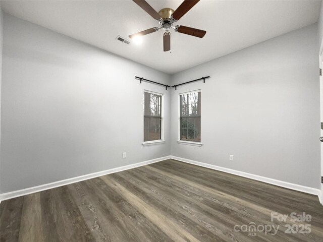 empty room with dark wood-type flooring and ceiling fan