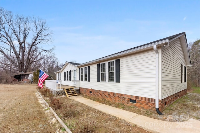 view of side of home featuring crawl space and a wooden deck