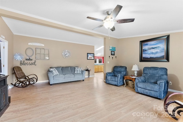 living room with crown molding, light wood-style flooring, and baseboards