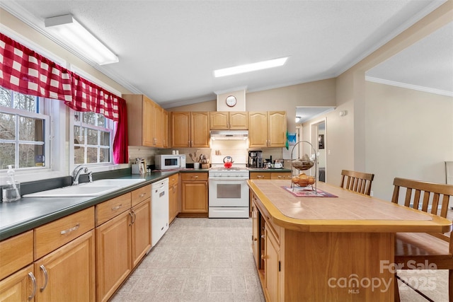 kitchen with white appliances, a kitchen island, ornamental molding, vaulted ceiling, and a sink