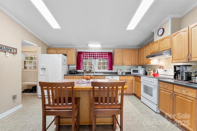 kitchen featuring white appliances, ornamental molding, vaulted ceiling, under cabinet range hood, and backsplash