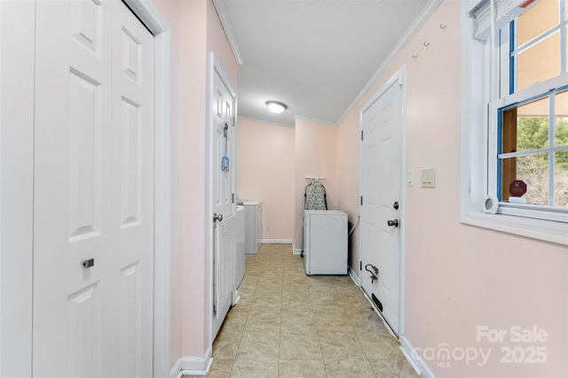 laundry room with laundry area, light tile patterned floors, baseboards, independent washer and dryer, and crown molding