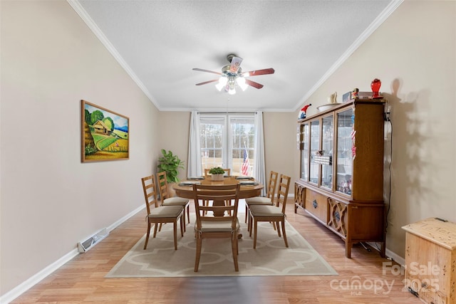 dining space with light wood finished floors, baseboards, ornamental molding, and a ceiling fan