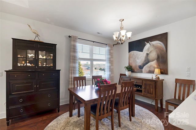 dining room featuring dark wood-type flooring and a notable chandelier