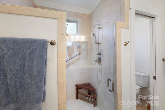 bathroom featuring toilet and an enclosed shower