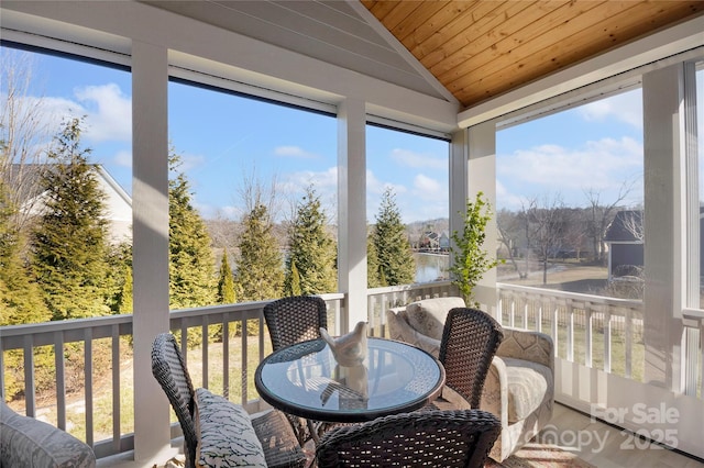 sunroom / solarium featuring a water view, lofted ceiling, a wealth of natural light, and wooden ceiling