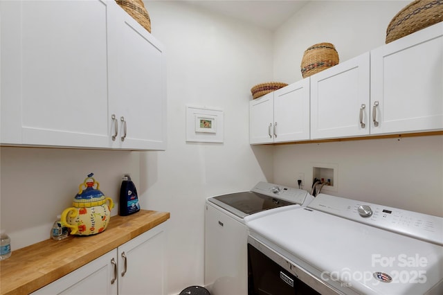 laundry area with washing machine and dryer and cabinets