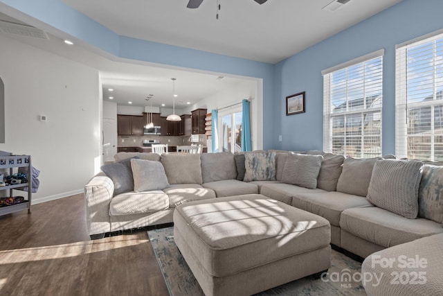 living room with ceiling fan, plenty of natural light, and dark hardwood / wood-style flooring