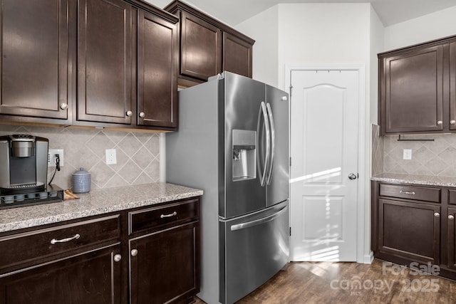 kitchen with dark brown cabinetry, stainless steel fridge with ice dispenser, backsplash, and dark hardwood / wood-style flooring