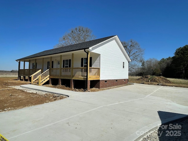 view of front facade featuring covered porch, driveway, and crawl space