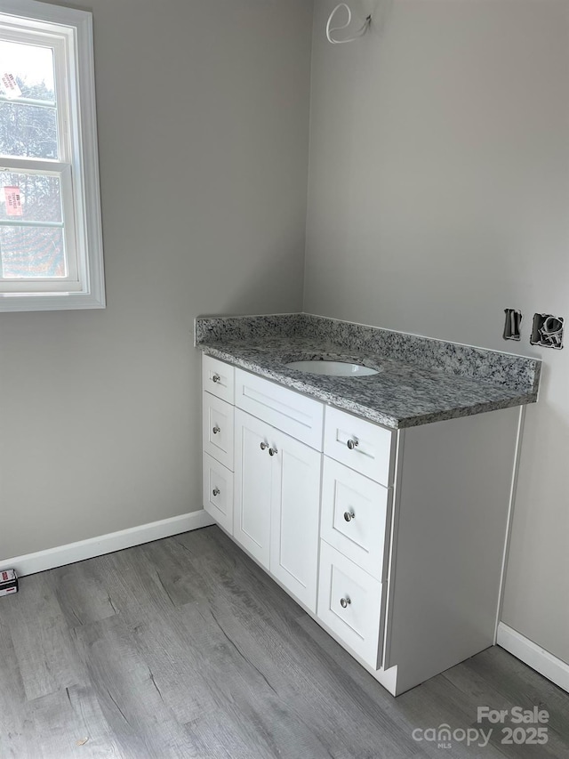 bathroom with vanity, baseboards, and wood finished floors