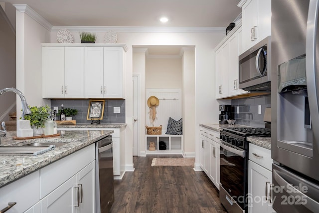 kitchen featuring sink, white cabinets, stainless steel appliances, light stone countertops, and dark wood-type flooring