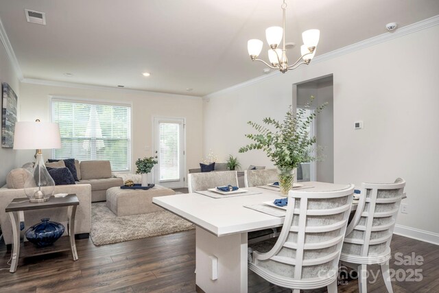 dining room featuring crown molding, dark hardwood / wood-style flooring, and a notable chandelier