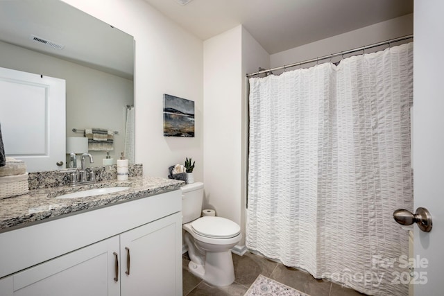 bathroom featuring vanity, tile patterned floors, and toilet