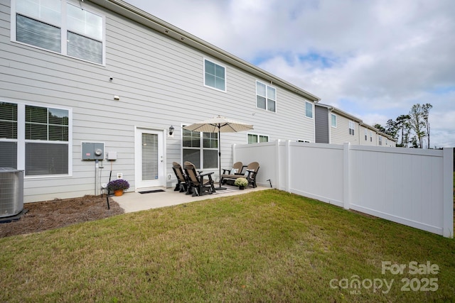 rear view of house featuring a patio, cooling unit, and a lawn