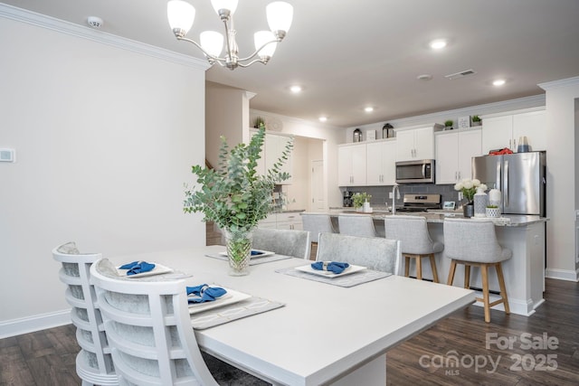 dining space with an inviting chandelier, ornamental molding, and dark hardwood / wood-style floors