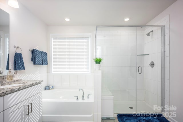 bathroom with a stall shower, recessed lighting, vanity, and a bath