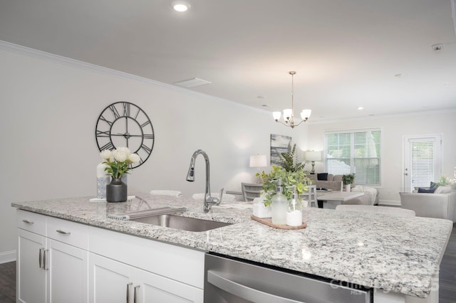 kitchen featuring crown molding, white cabinetry, a sink, open floor plan, and stainless steel dishwasher