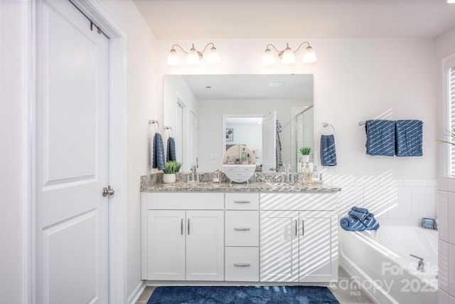 bathroom featuring a shower stall, a sink, double vanity, and a garden tub