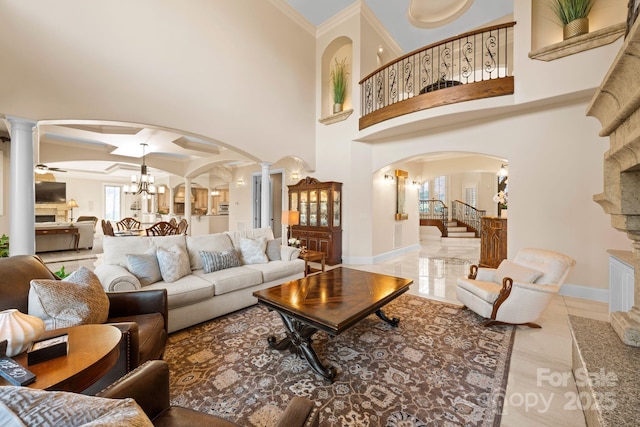 living room featuring a wealth of natural light, arched walkways, and ornate columns