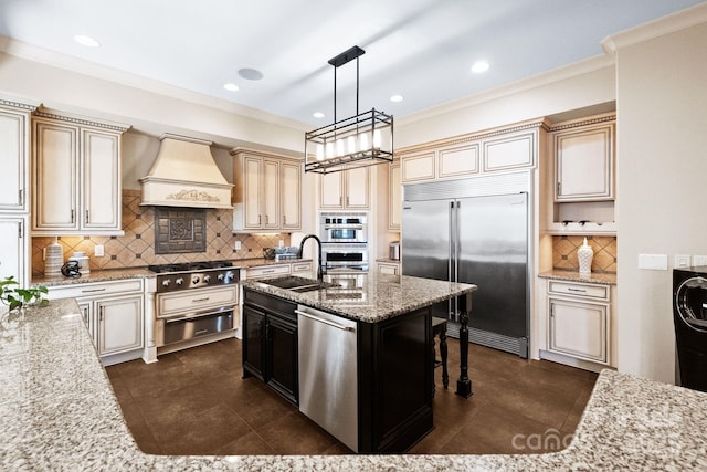 kitchen featuring appliances with stainless steel finishes, cream cabinets, custom exhaust hood, a warming drawer, and a sink