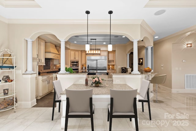 dining room featuring crown molding, baseboards, visible vents, and ornate columns