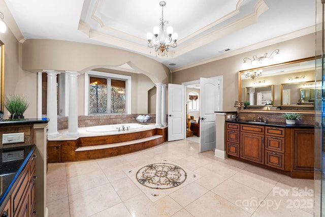 bathroom featuring visible vents, a garden tub, a tray ceiling, ornamental molding, and ornate columns