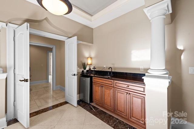 bathroom featuring baseboards, ornamental molding, marble finish floor, ornate columns, and a sink