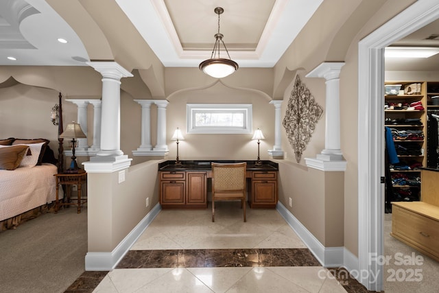 interior space featuring a raised ceiling, recessed lighting, decorative columns, baseboards, and built in study area