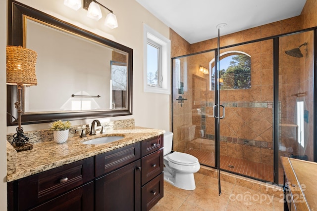 bathroom with vanity, toilet, a shower stall, and tile patterned flooring